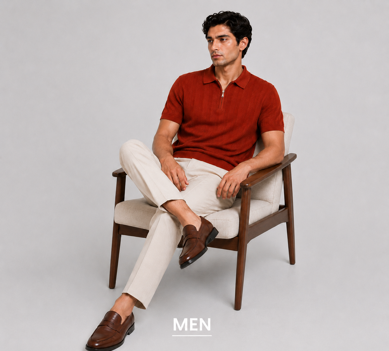 Man sitting on a chair wearing a red polo shirt and white pants, with 'MEN' text at the bottom.